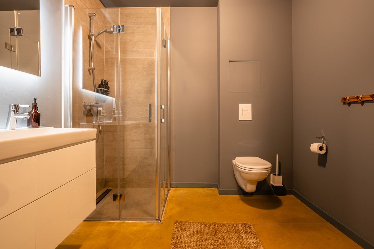 Badkamer met inloopdouche, zwevend toilet en brede wastafel