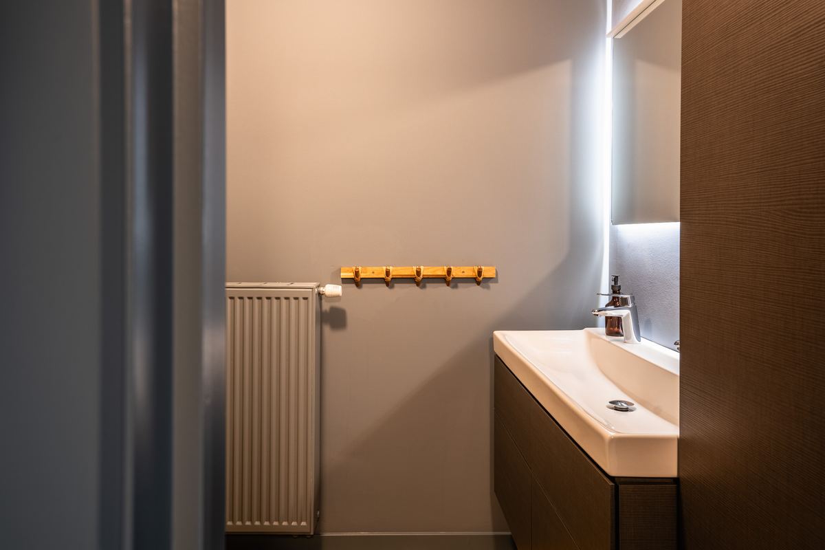 Wastafel met verlichte spiegelnis in een rustige badkamer
