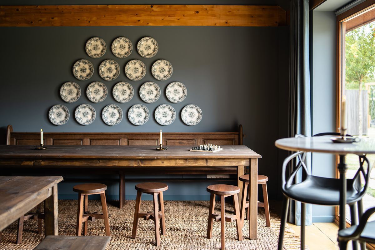 Verzameling blauwe borden aan de wand boven een lange tafel met krukken