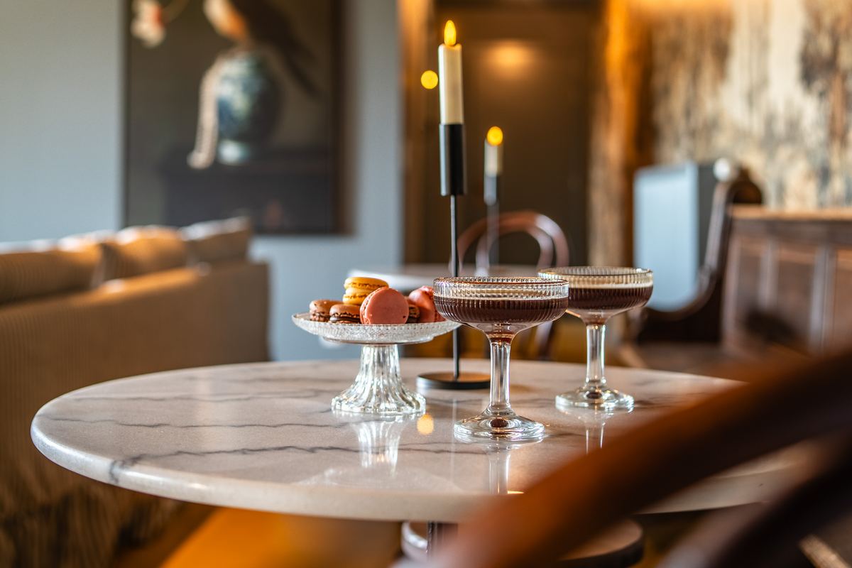 Coupes en macarons op een marmeren tafeltje bij kaarslicht