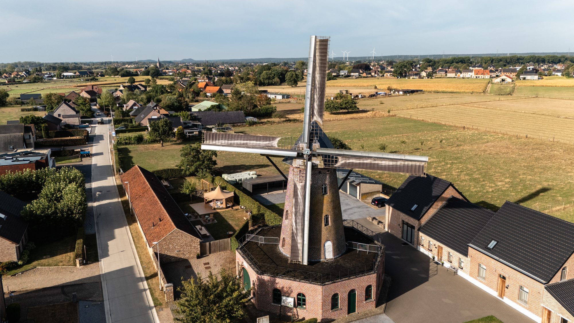 De Maasvallei rond Elen — Luchtfoto van de molen boven de daken van Elen met de Maasvallei op de achtergrond