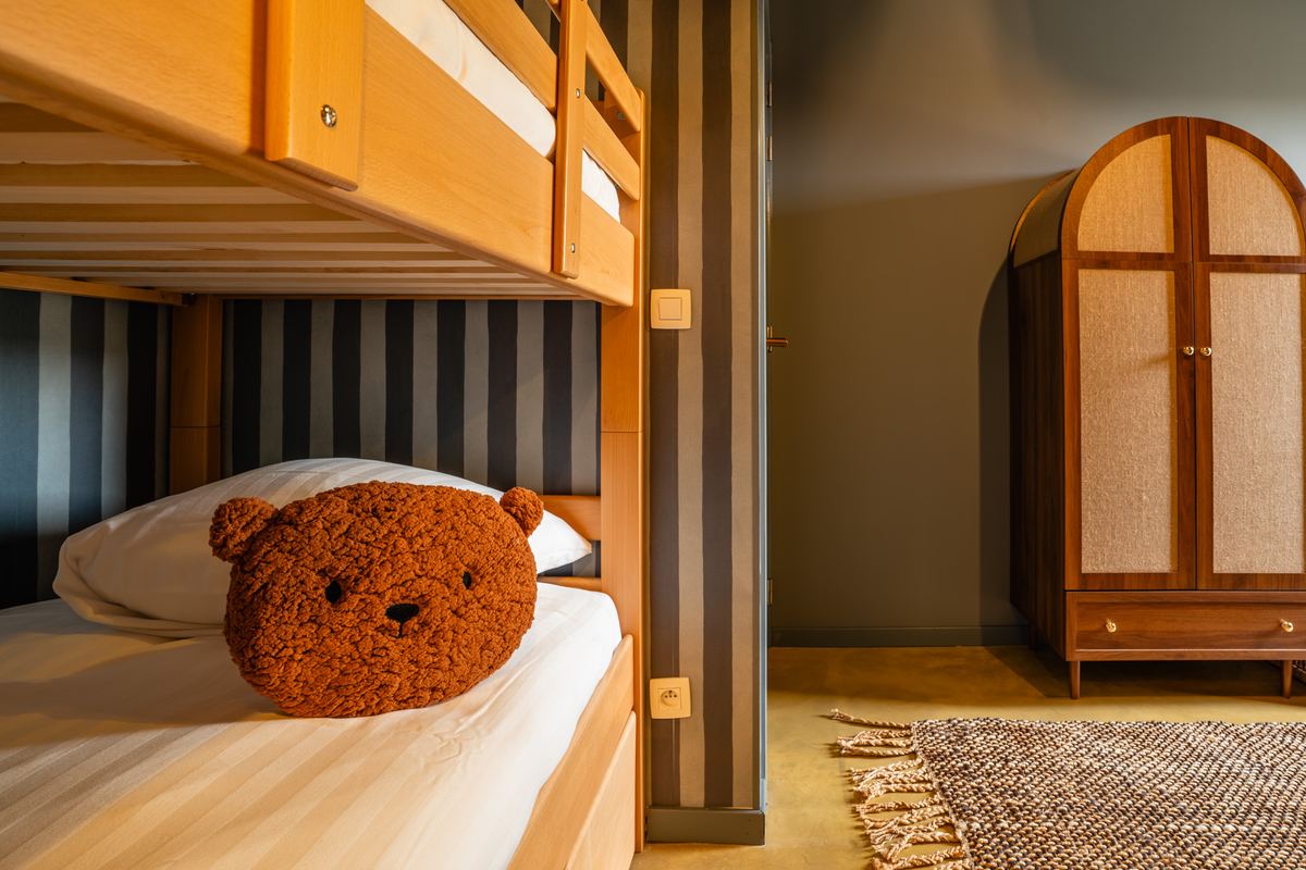 Onderste stapelbed met een bruin berenkussen op het kussen