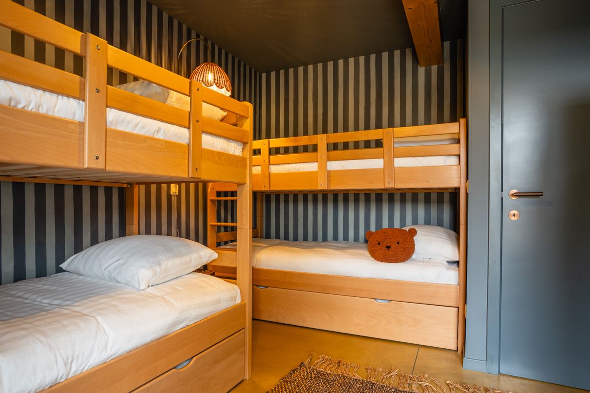 Twee houten stapelbedden naast elkaar in de kinderkamer