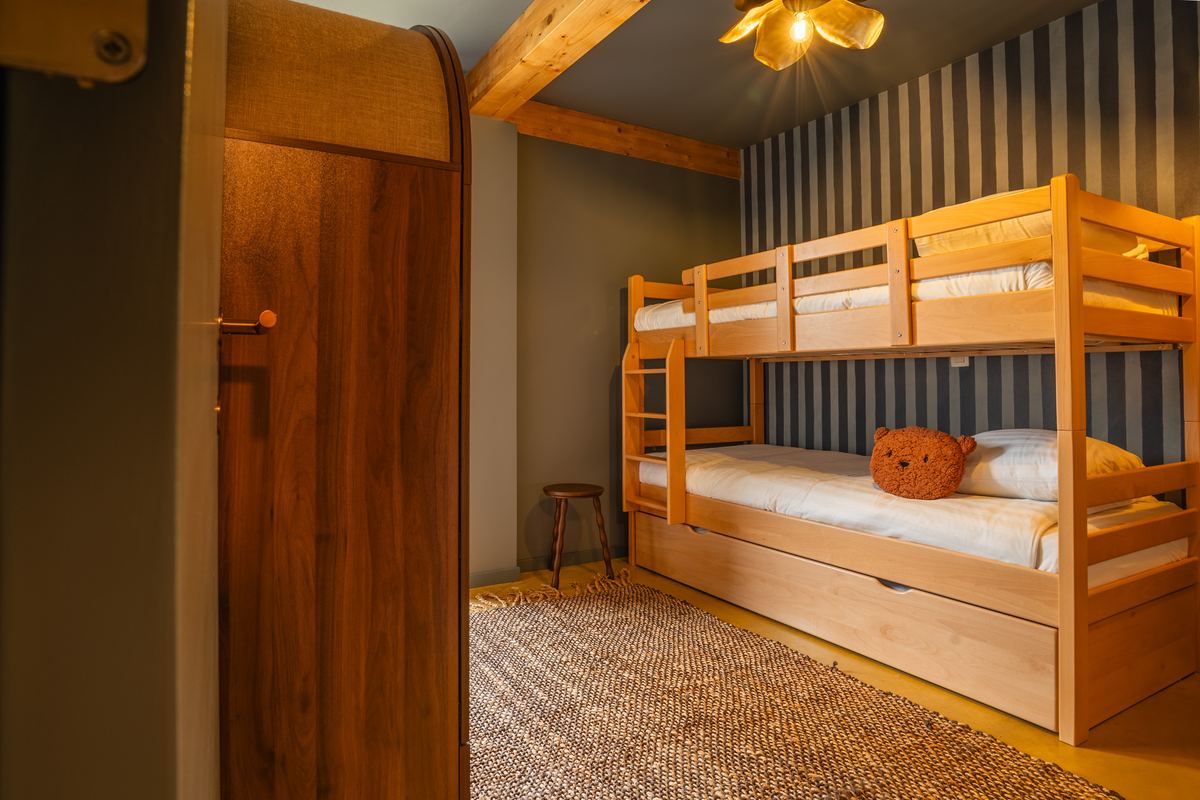 Slaapkamer met houten stapelbedden en gestreept behang