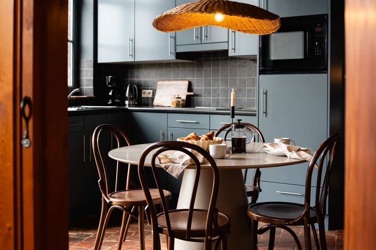 Kleine keuken met ronde tafel en bistrostoelen, gedekt voor het ontbijt